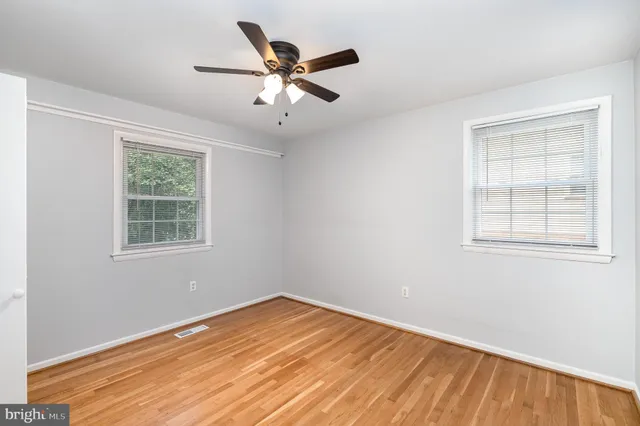 a view of a big room with wooden floor closet and windows