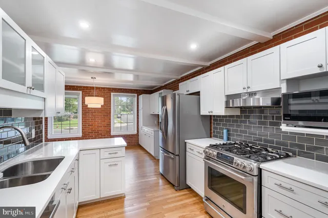 a kitchen with granite countertop a sink a counter space stainless steel appliances and cabinets