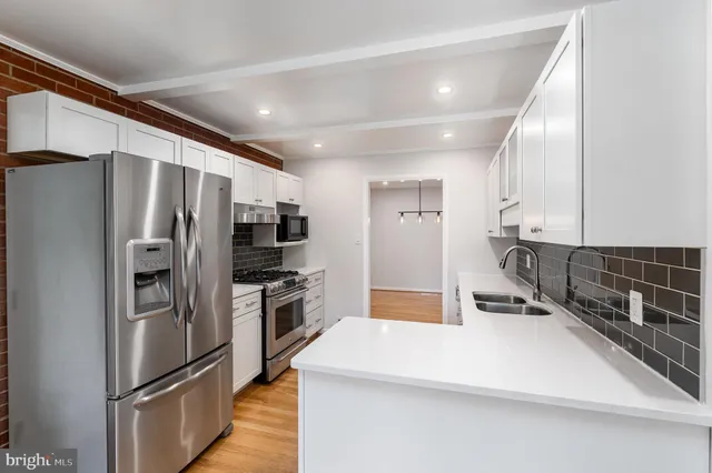 a kitchen with stainless steel appliances a refrigerator and a stove top oven