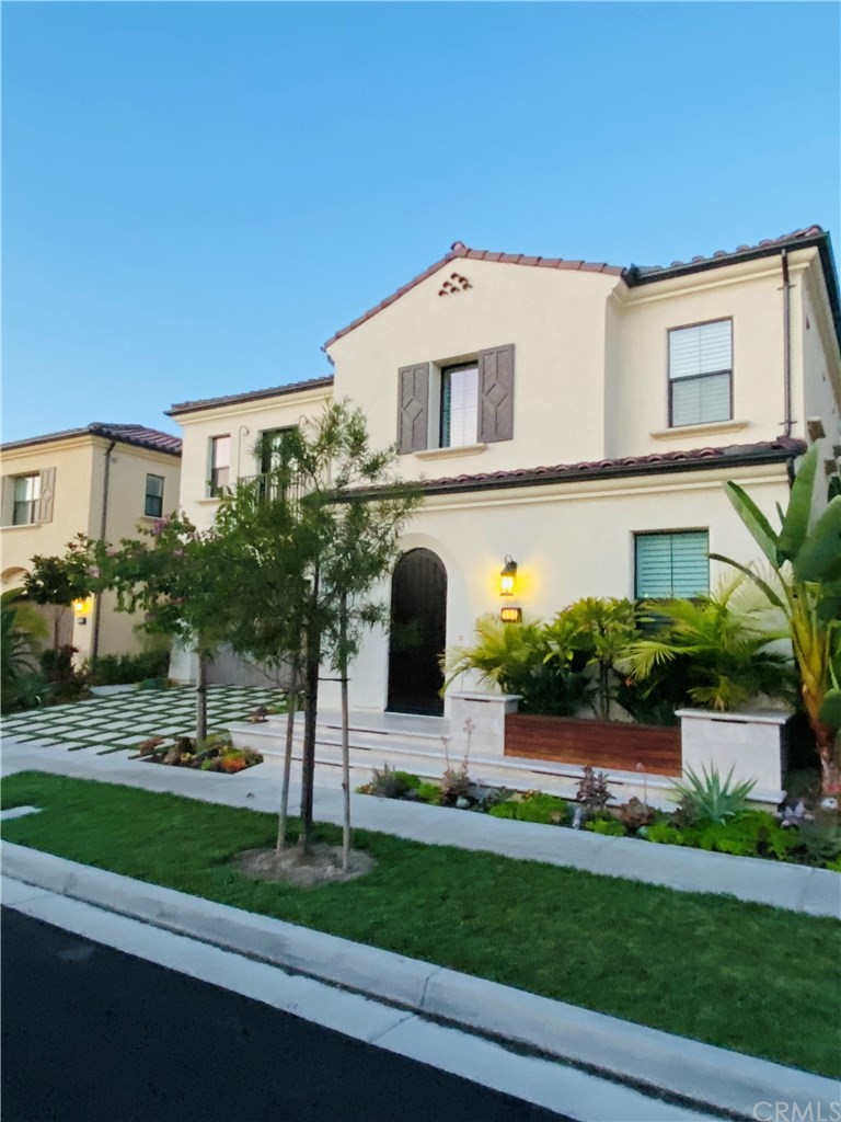 a front view of a house with a yard and potted plants