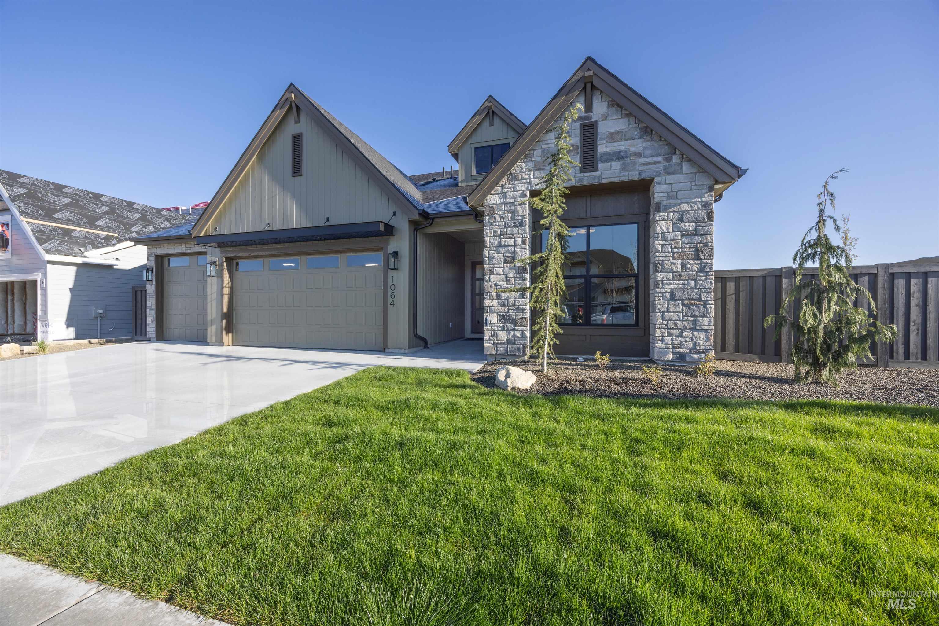 5847 South Pinpoint Way Meridian, ID 83642 - Photo 2 of 44 View of front facade featuring an attached garage, stone siding, and driveway