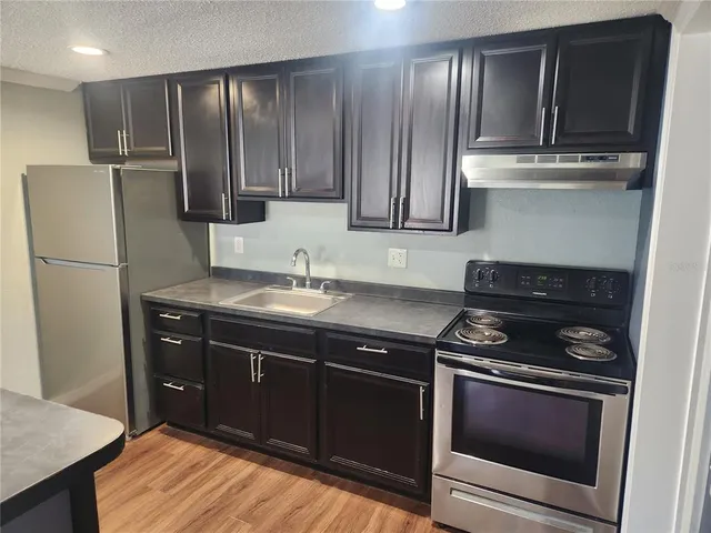 a kitchen with stainless steel appliances wooden cabinets and stove