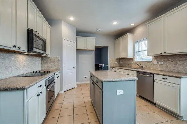 a kitchen with a sink stove top oven and cabinets