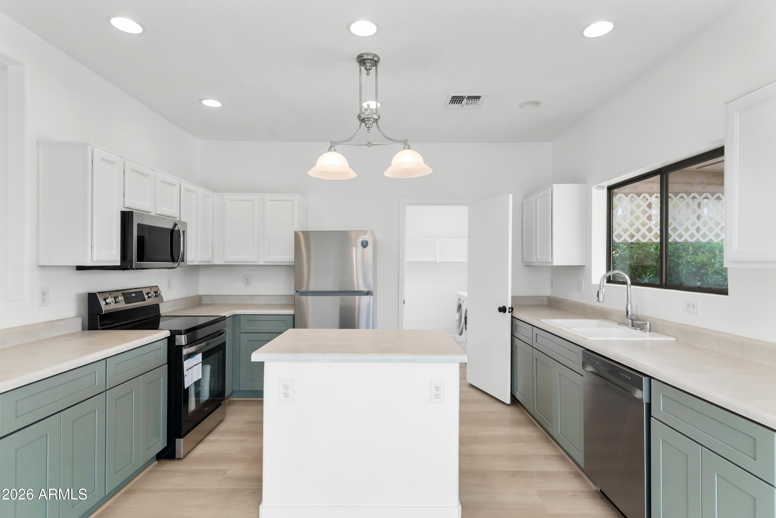 930 East Pedro Road Phoenix, AZ 85042 - Photo 10 of 34 a kitchen with stainless steel appliances a sink dishwasher a stove top oven a refrigerator with white cabinets and wooden floor