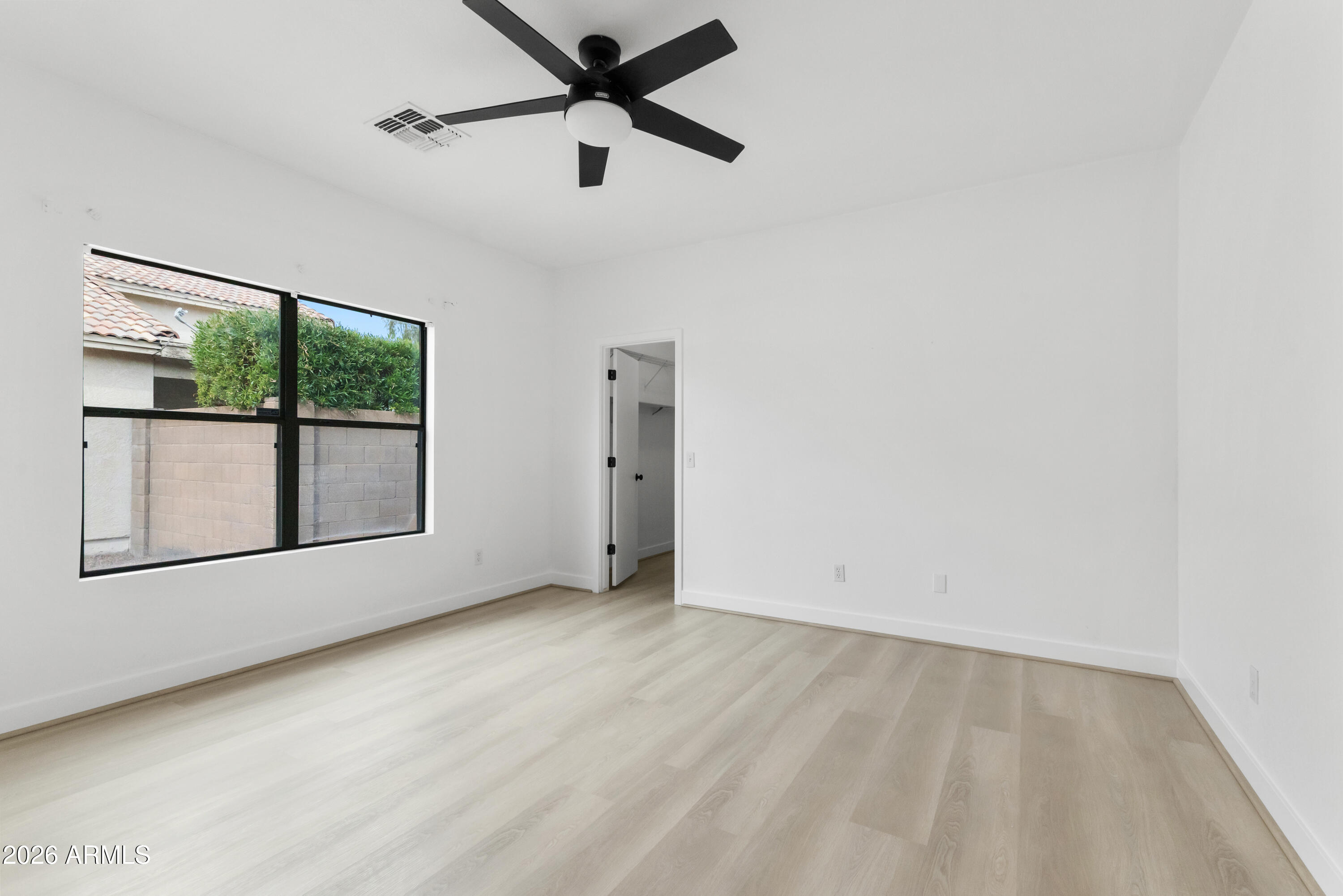 930 East Pedro Road Phoenix, AZ 85042 - Photo 16 of 34 an empty room with large windows and a ceiling fan