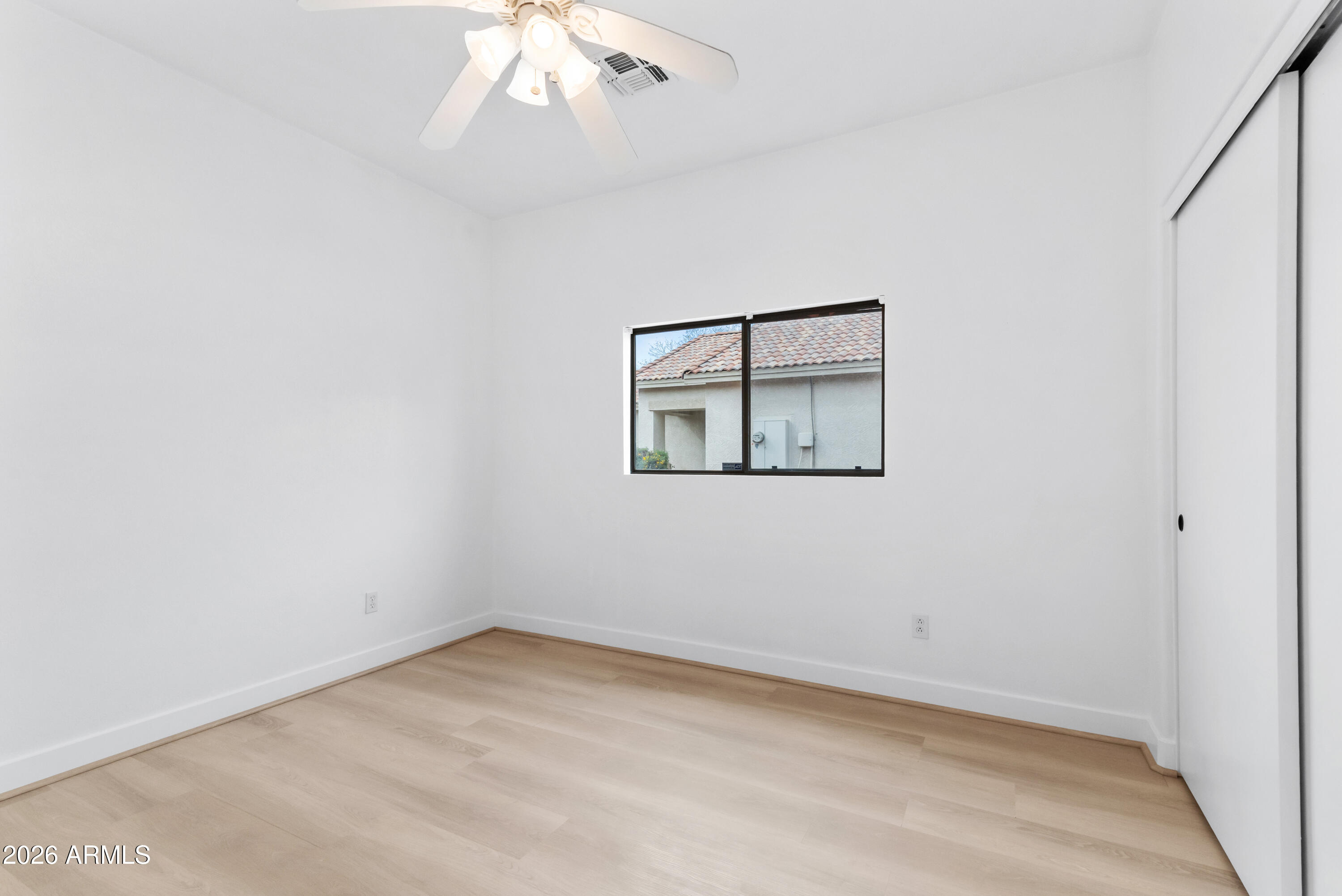 930 East Pedro Road Phoenix, AZ 85042 - Photo 21 of 34 an empty room with a chandelier fan and windows