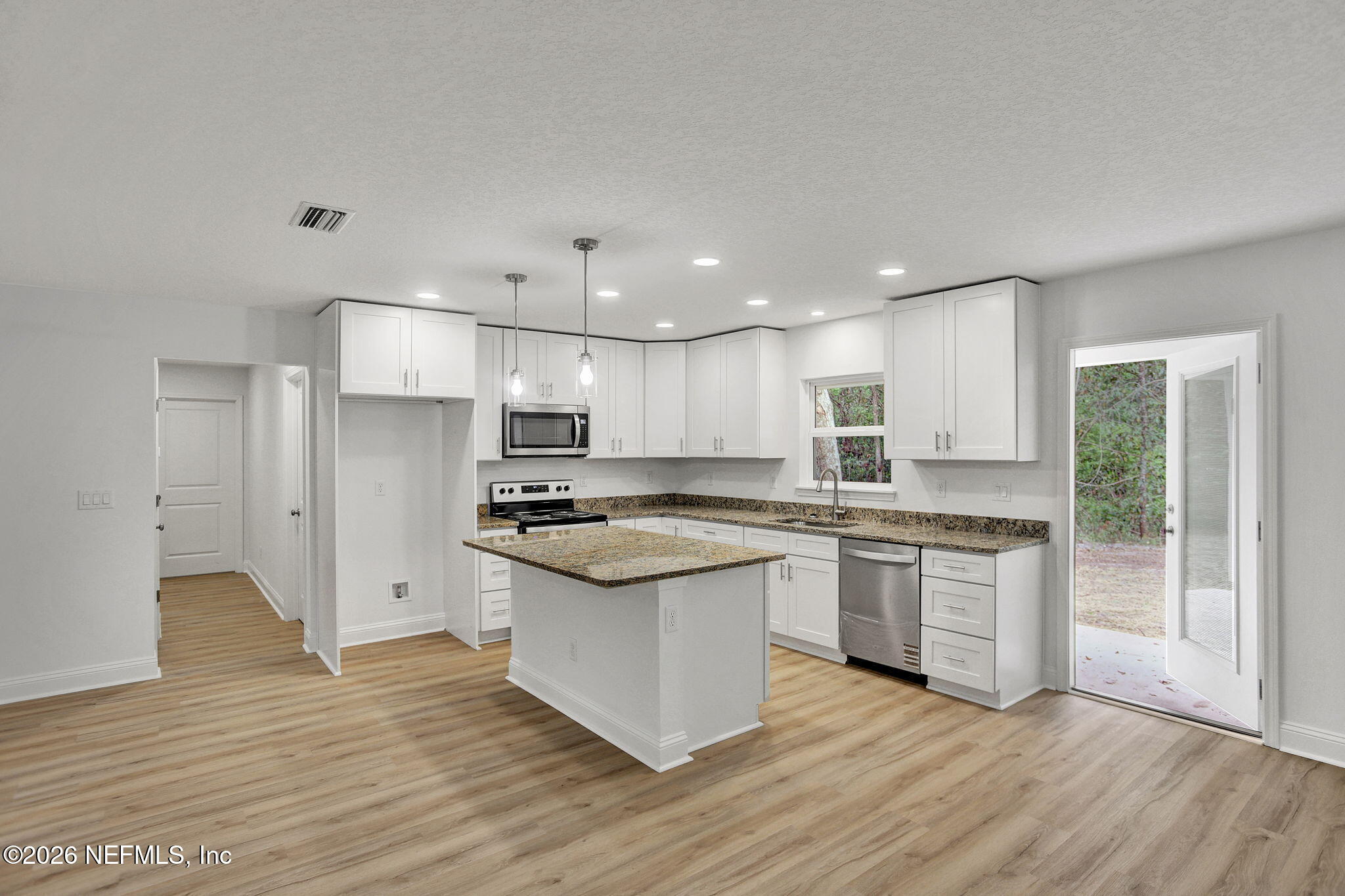 4881 Chickpea Street Middleburg, FL 32068 - Photo 4 of 19 a large kitchen with stainless steel appliances granite countertop a stove and a sink