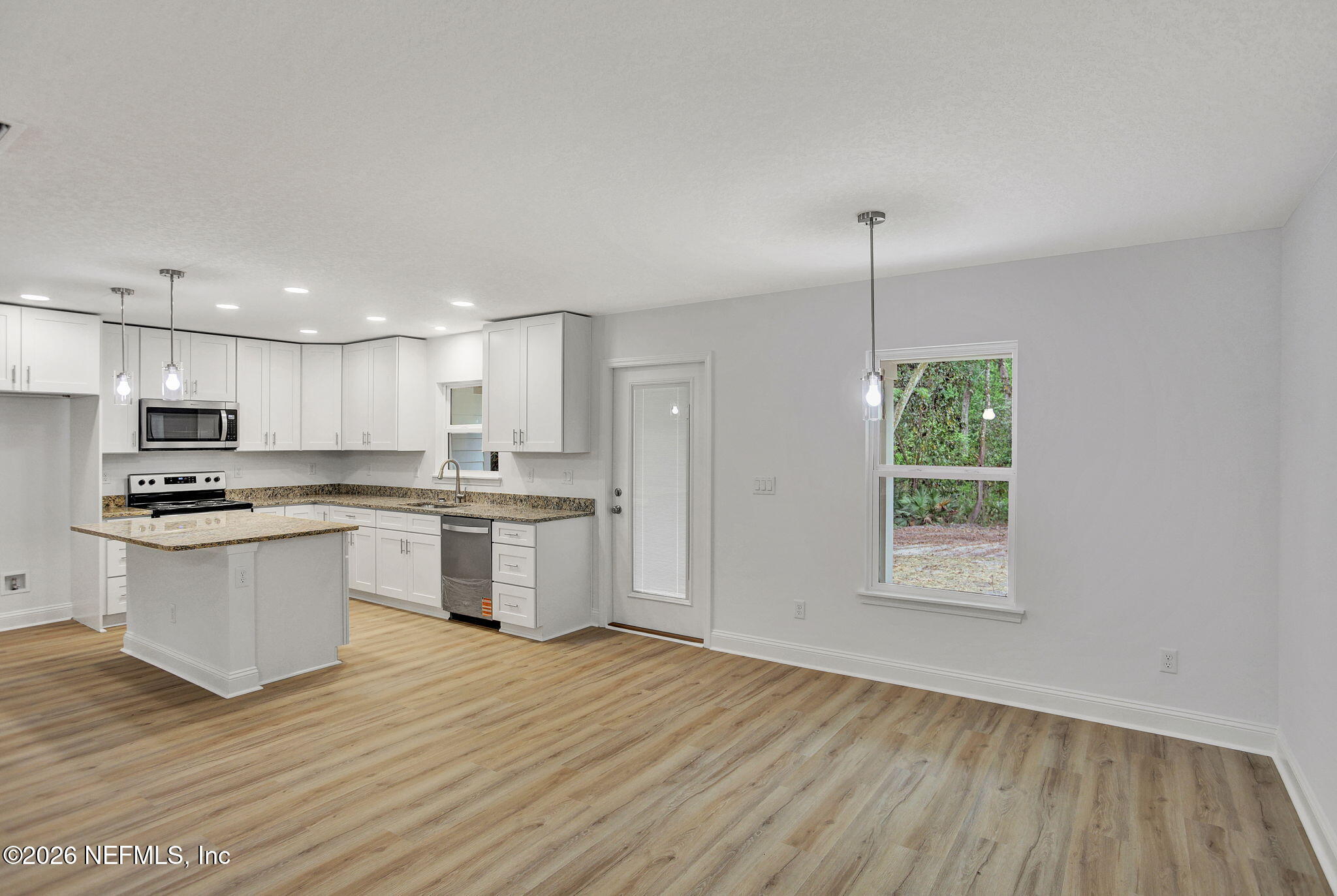 4881 Chickpea Street Middleburg, FL 32068 - Photo 6 of 19 a kitchen with a sink wooden floor and stainless steel appliances