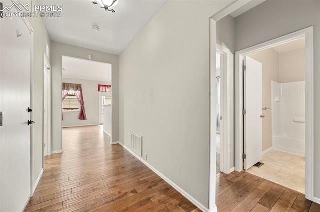 11927 Rodez Grove Peyton, CO 80831 - Photo 3 of 34 Corridor with wood finished floors, visible vents, and baseboards