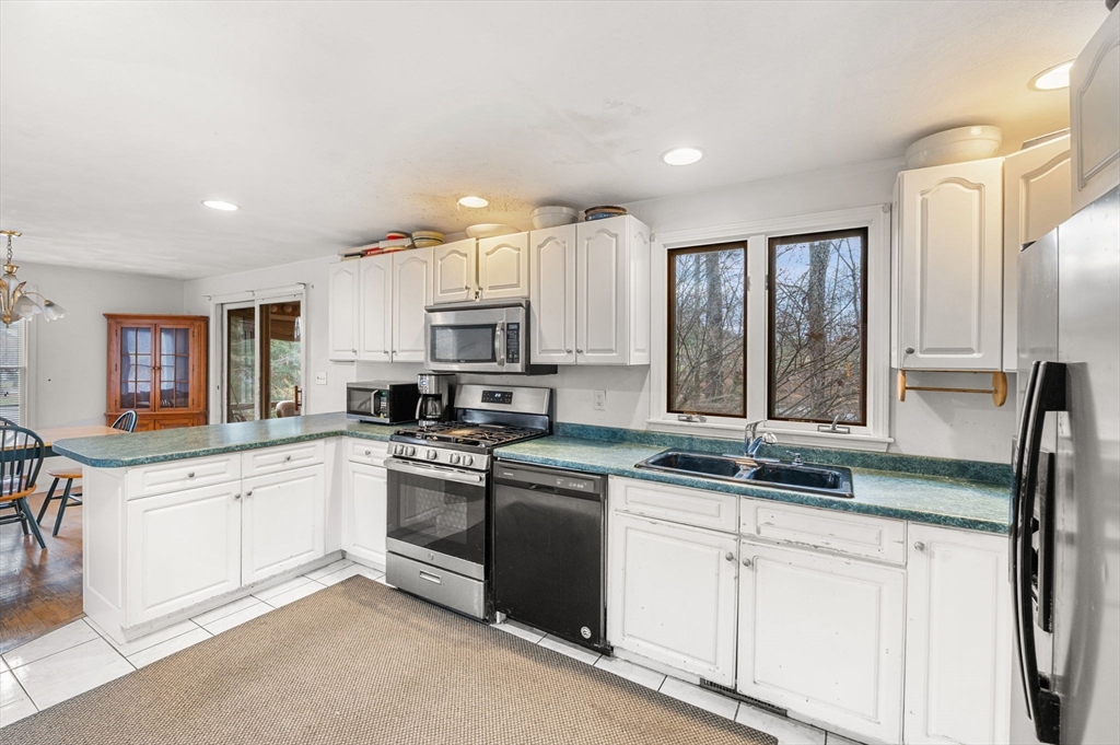 328 East Broadway Haverhill, MA 01830 - Photo 18 of 37 a kitchen with granite countertop white cabinets and white appliances