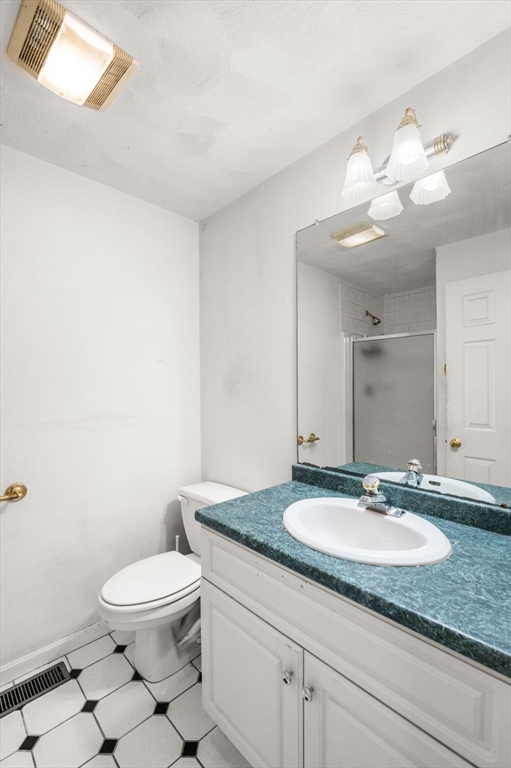 328 East Broadway Haverhill, MA 01830 - Photo 22 of 37 a bathroom with a granite countertop sink a toilet and a mirror