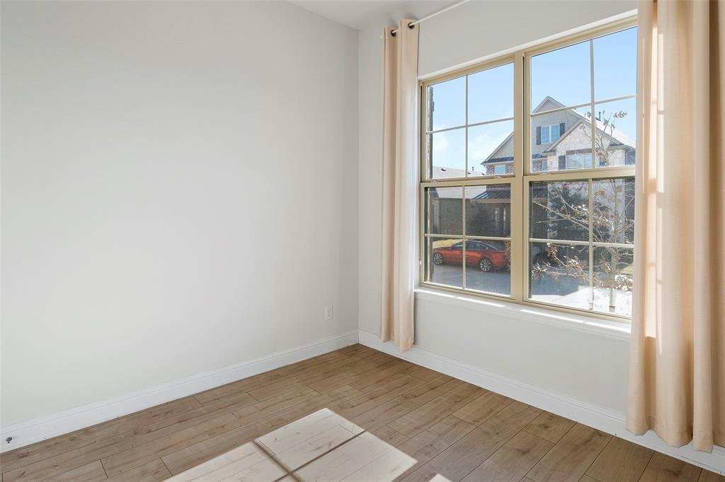 8211 Agarito Way Dallas, TX 75252 - Photo 12 of 34 an empty room with wooden floor and a window