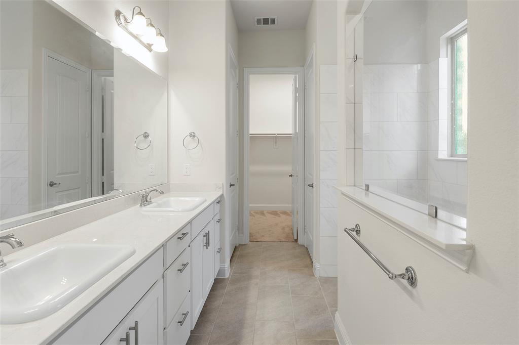 8211 Agarito Way Dallas, TX 75252 - Photo 15 of 34 a spacious bathroom with a double vanity sink a mirror and a shower