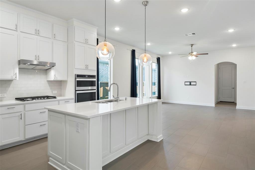8211 Agarito Way Dallas, TX 75252 - Photo 3 of 34 a large white kitchen with a stove a sink a refrigerator and a refrigerator