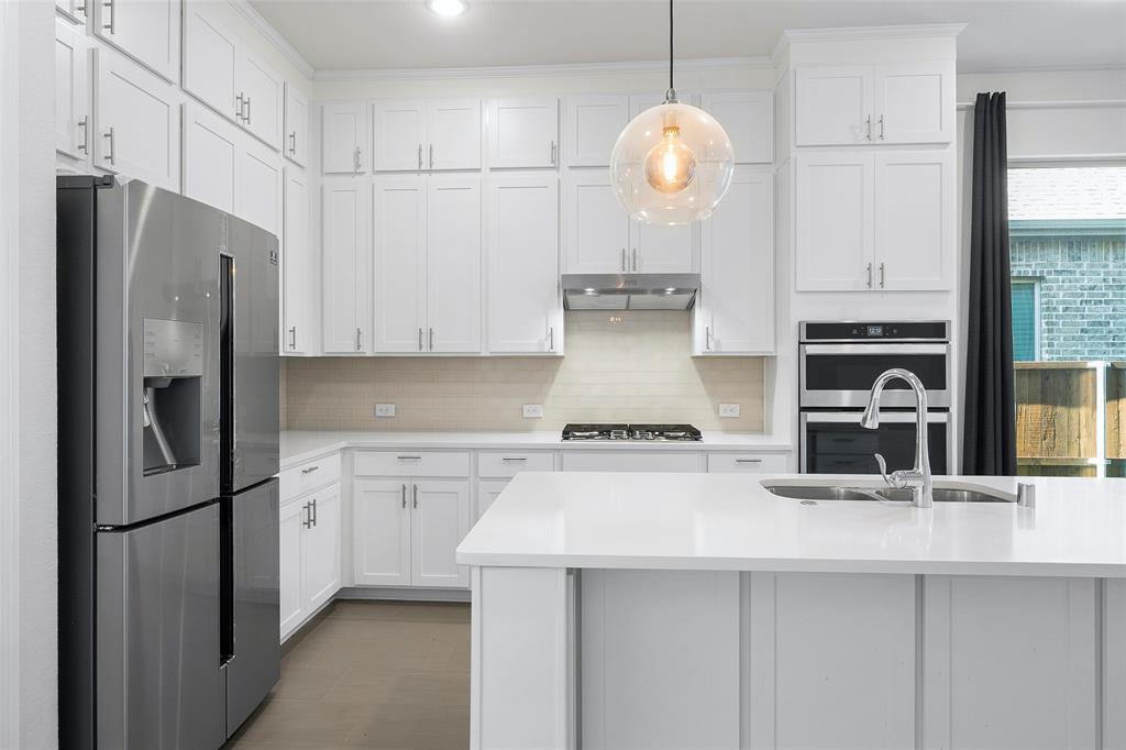 8211 Agarito Way Dallas, TX 75252 - Photo 4 of 34 a kitchen with stainless steel appliances a refrigerator sink and cabinets