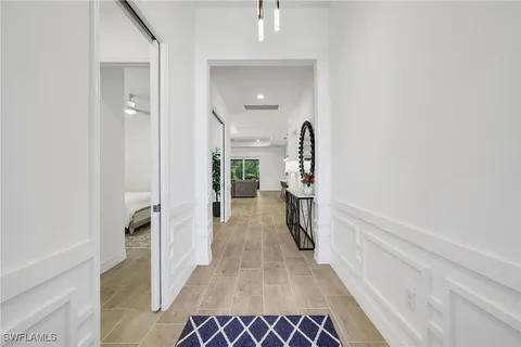 a kitchen with stainless steel appliances granite countertop a sink a stove a refrigerator and white cabinets with wooden floor