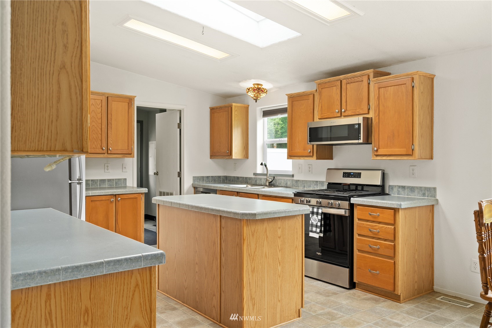 16227 OK Mill Road Snohomish, WA 98290 - Photo 14 of 38 a kitchen with stainless steel appliances granite countertop wooden cabinets sink and a granite counter top