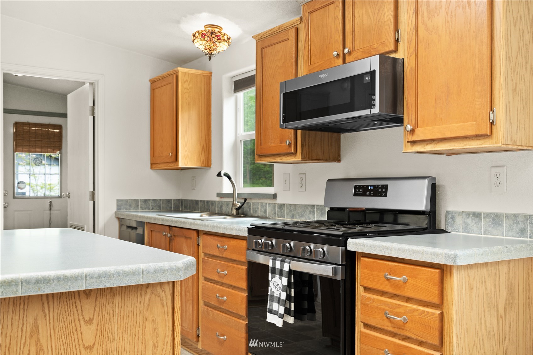 16227 OK Mill Road Snohomish, WA 98290 - Photo 15 of 38 a kitchen with stainless steel appliances granite countertop a sink stove and microwave