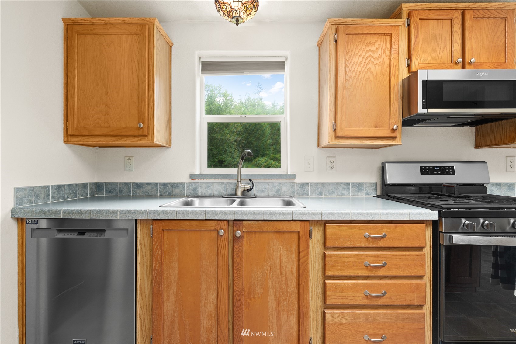 16227 OK Mill Road Snohomish, WA 98290 - Photo 16 of 38 a kitchen with stainless steel appliances granite countertop a sink stove and microwave