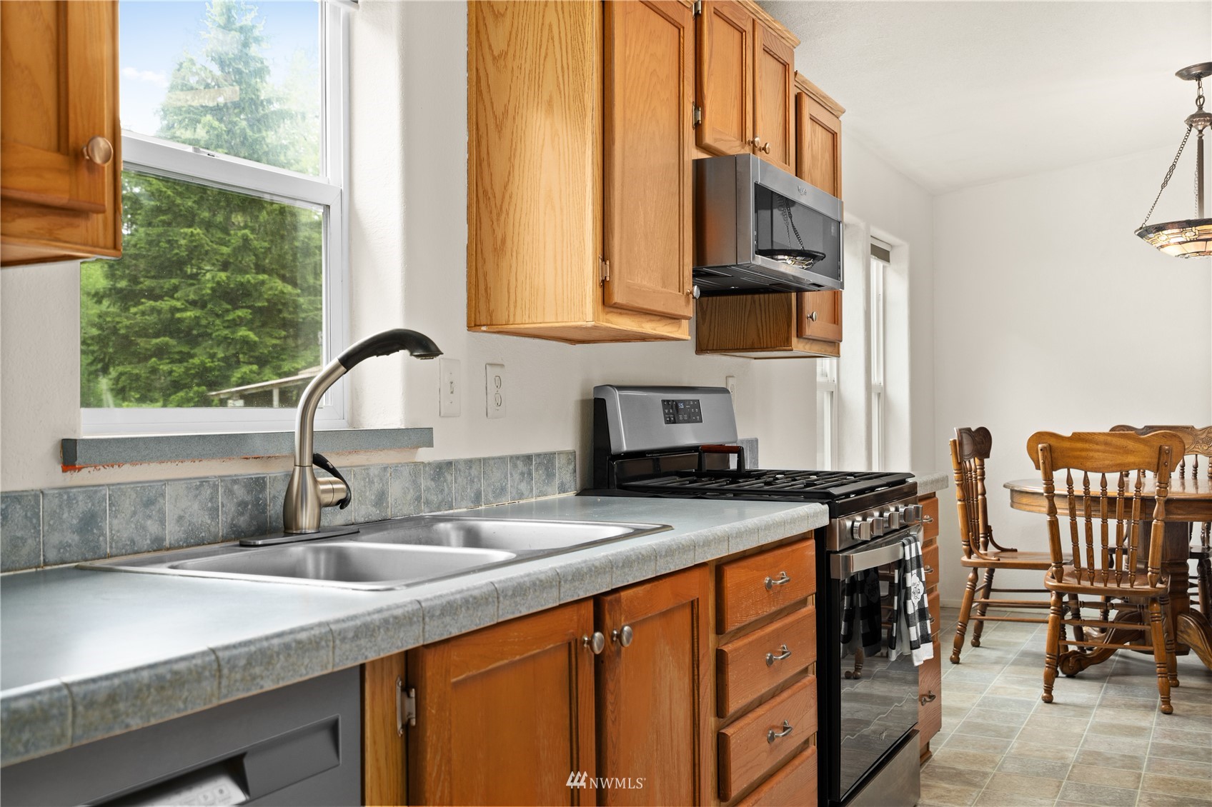 16227 OK Mill Road Snohomish, WA 98290 - Photo 17 of 38 a kitchen with stainless steel appliances granite countertop a sink a stove and a wooden cabinets