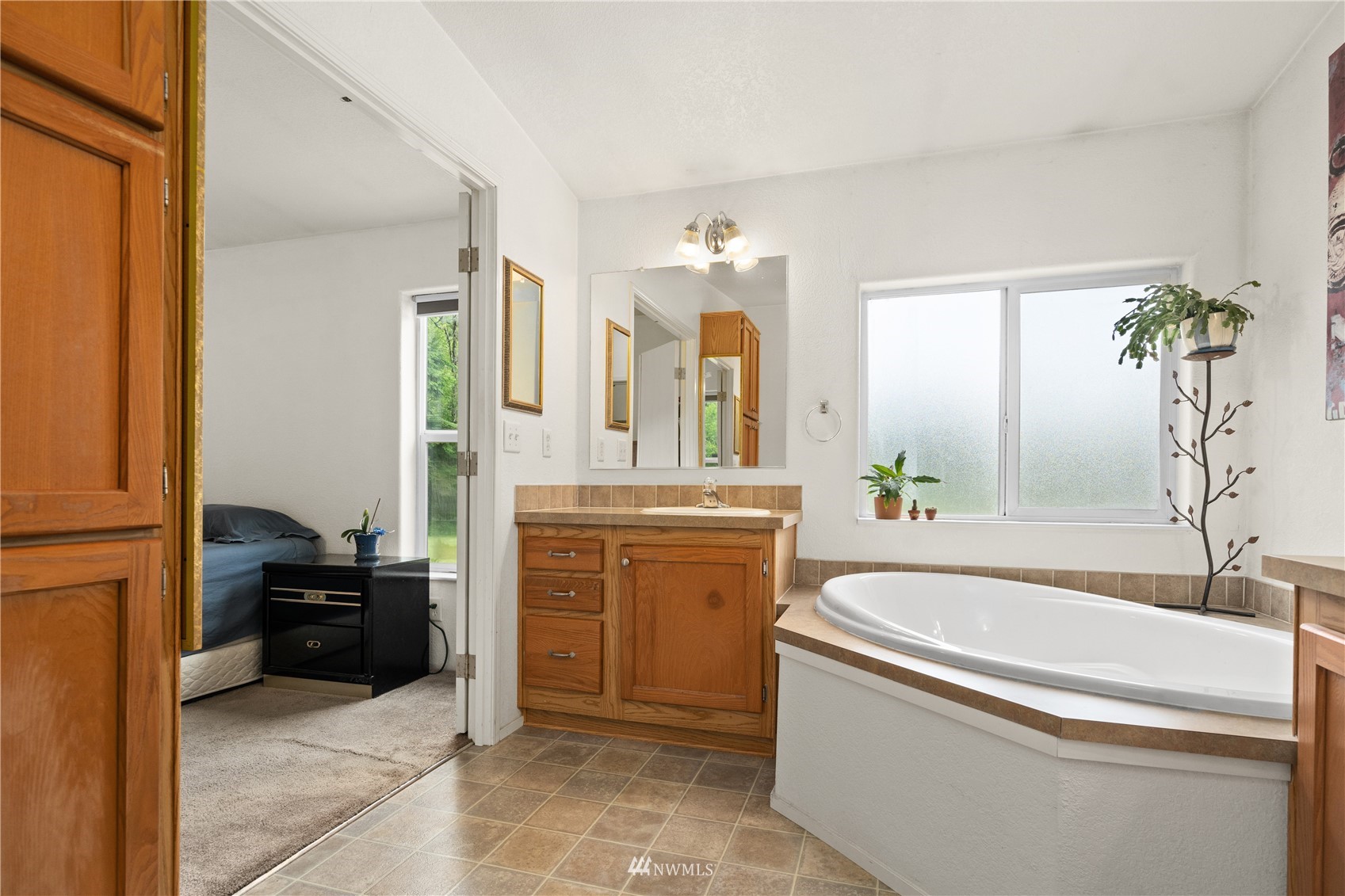 16227 OK Mill Road Snohomish, WA 98290 - Photo 28 of 38 a bathroom with a bathtub sink and mirror