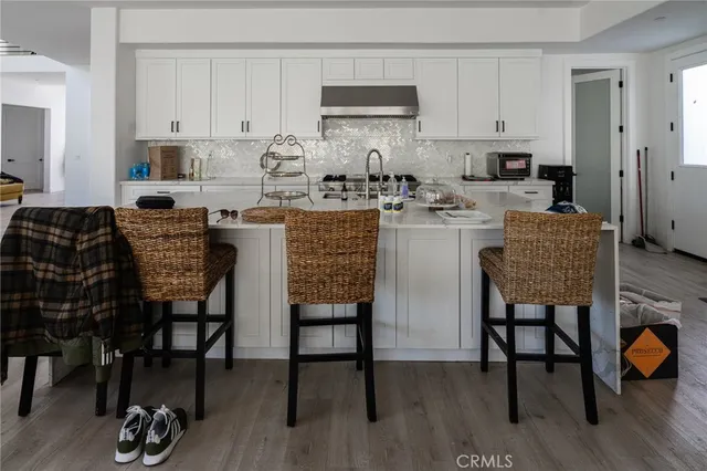 a kitchen with stainless steel appliances granite countertop a table and chairs in it