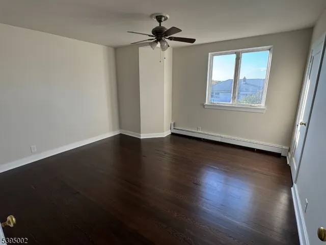 a view of room with window ceiling fan and hardwood floor