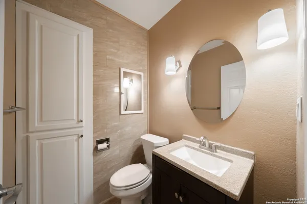 a bathroom with a sink a toilet and a mirror