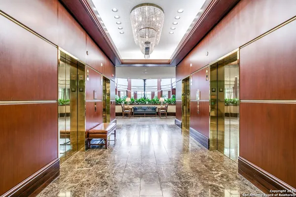 a view of a hallway with wooden floor and a potted plant