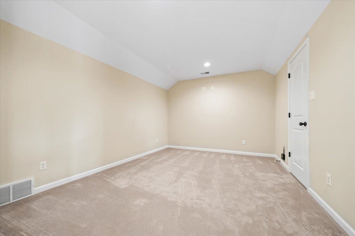 740 Frazier Road Rossville, TN 38066 - Photo 27 of 40 Spacious room featuring neutral carpeting, light beige walls, white trim, recessed lighting, and a white interior door with dark hardware