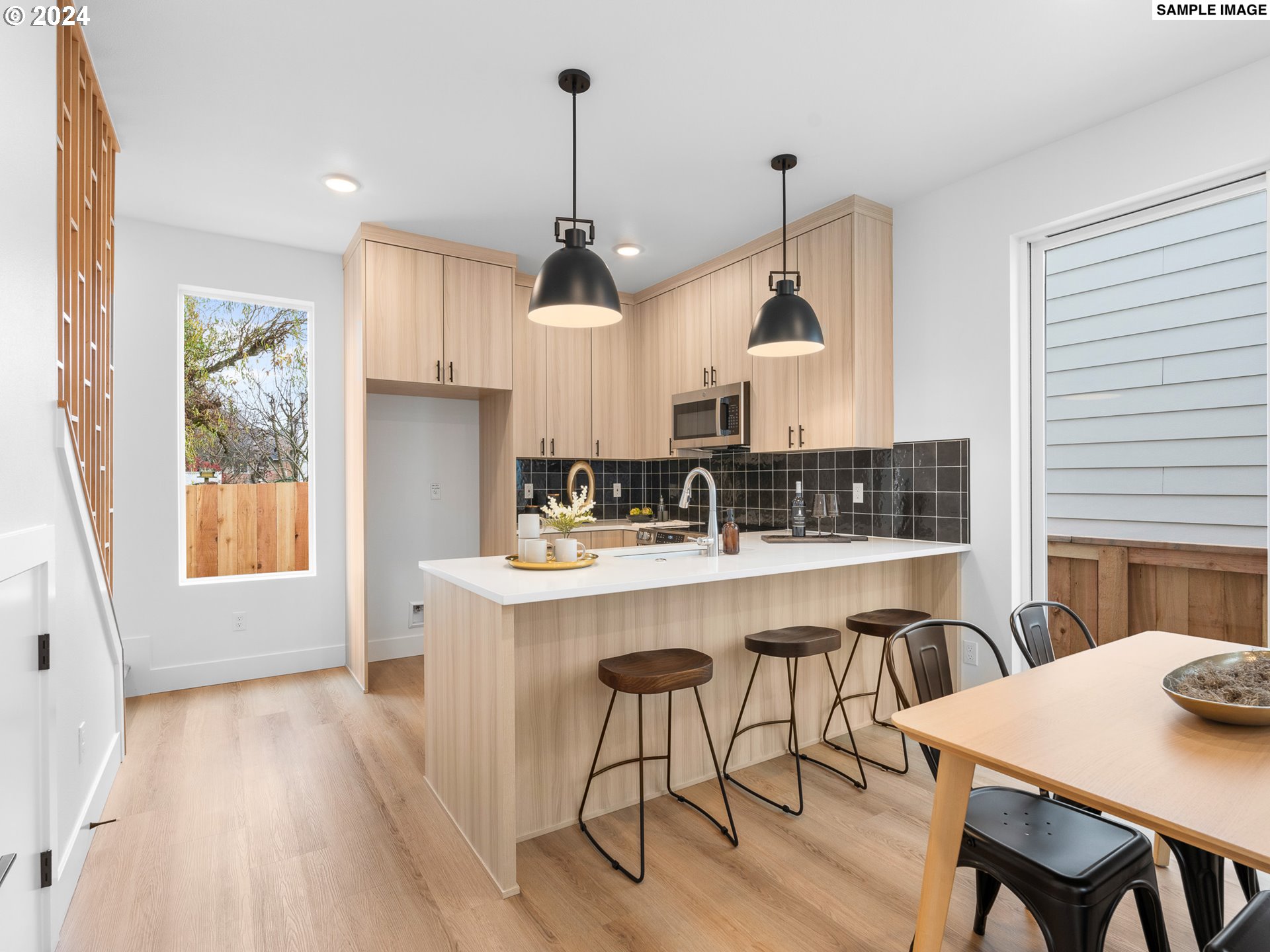 6195 North Amherst Street Portland, OR 97203 - Photo 5 of 20 a kitchen with a sink a stove a dining table and chairs