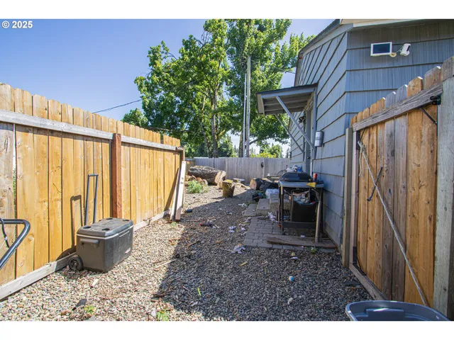 a view of a backyard with chairs and a potted plant