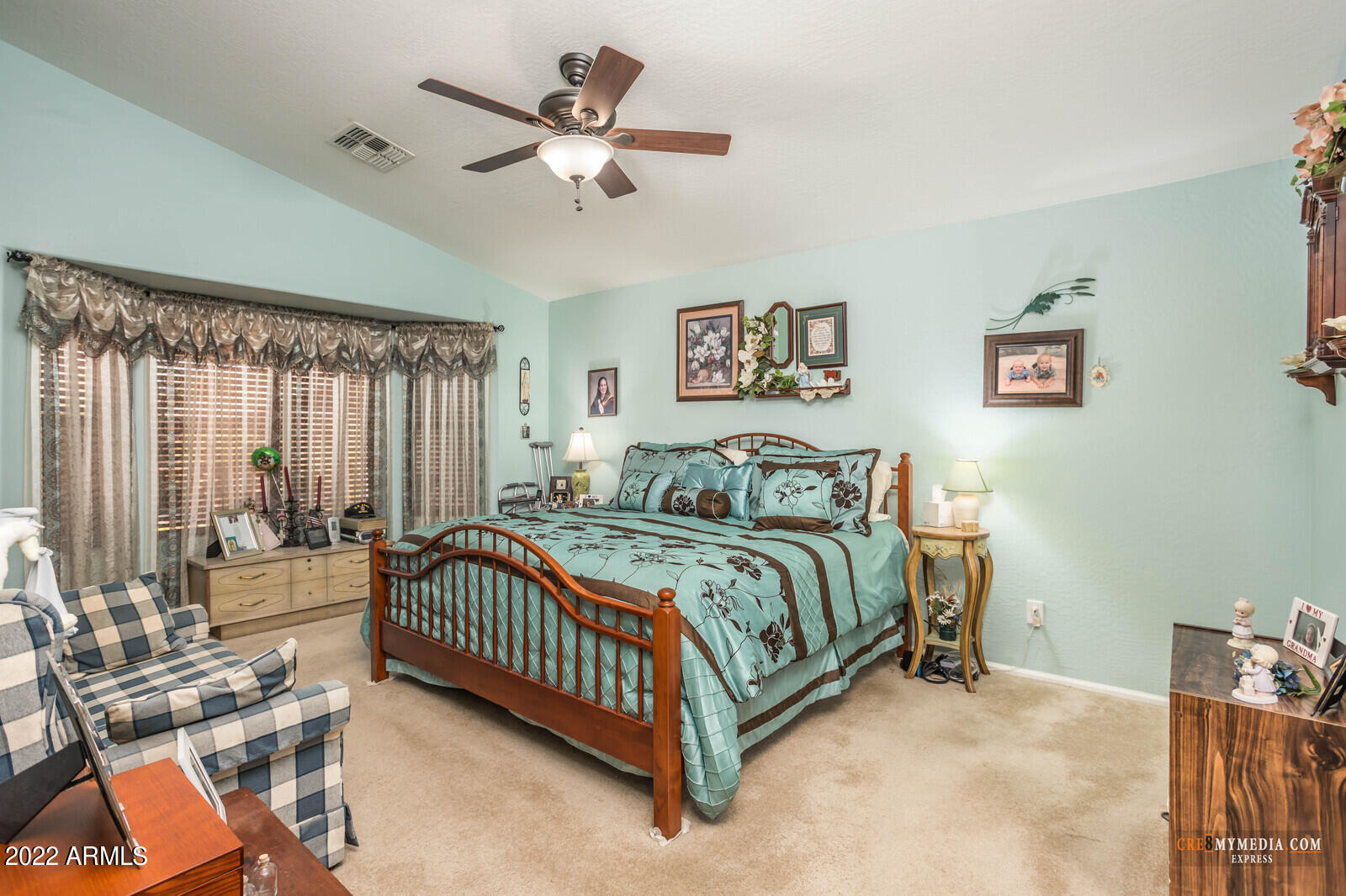 45083 West Norris Road Maricopa, AZ 85139 - Photo 19 of 35 a spacious bedroom with a bed a window and a chandelier