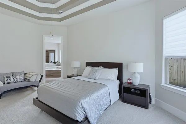 a bedroom with a bed and a lamp on dresser