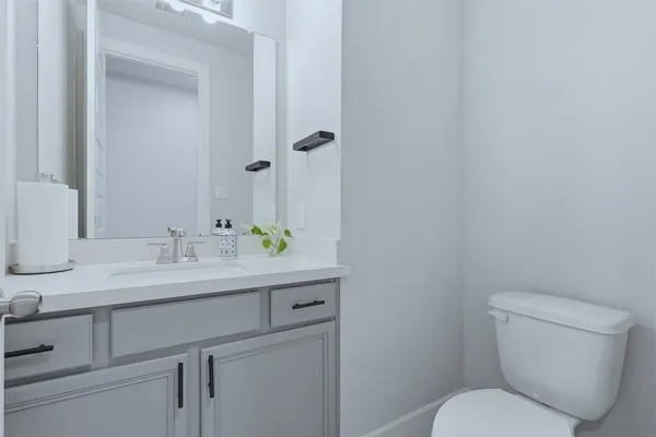 a bathroom with a toilet sink and mirror