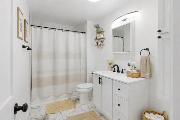 a bathroom with a sink toilet and shower