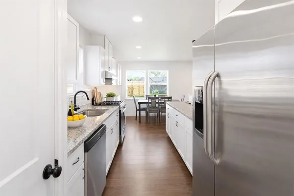 a kitchen with stainless steel appliances granite countertop lots of counter top space and wooden floor