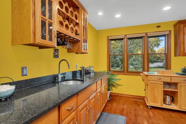 a kitchen with stainless steel appliances granite countertop a sink and a stove next to a window