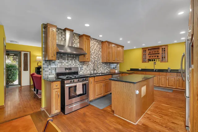 a kitchen with stainless steel appliances granite countertop a stove a sink and a refrigerator