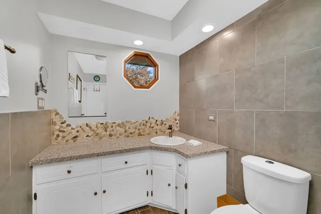 a bathroom with a sink a toilet and a mirror