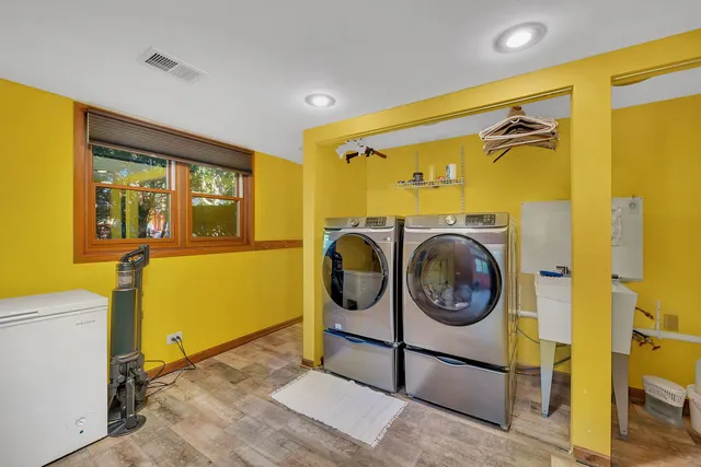 a view of a bathroom with washing machine and mirrors