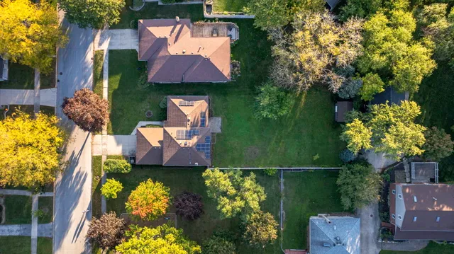 an aerial view of a house with a garden and lake view