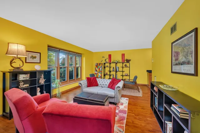 a living room with furniture kitchen view and a large window