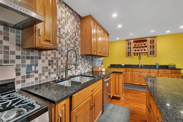 a kitchen with stainless steel appliances granite countertop a sink stove and refrigerator