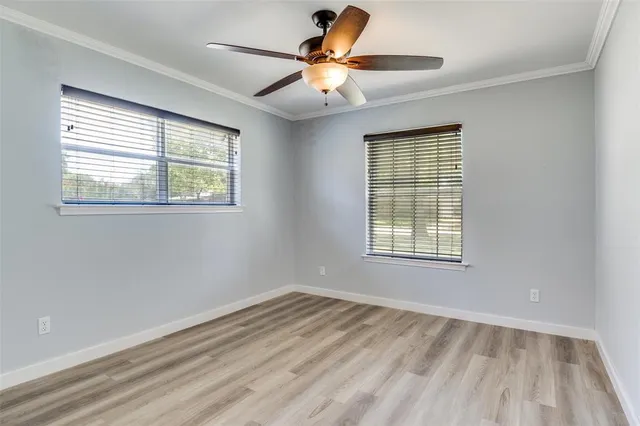 a view of an empty room with a window and a ceiling fan