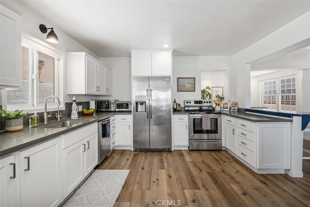 3810 Channel Place Newport Beach, CA 92663 - Photo 19 of 43 a kitchen with granite countertop white cabinets and white appliances