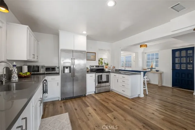 a kitchen with stainless steel appliances granite countertop a refrigerator a stove and a sink