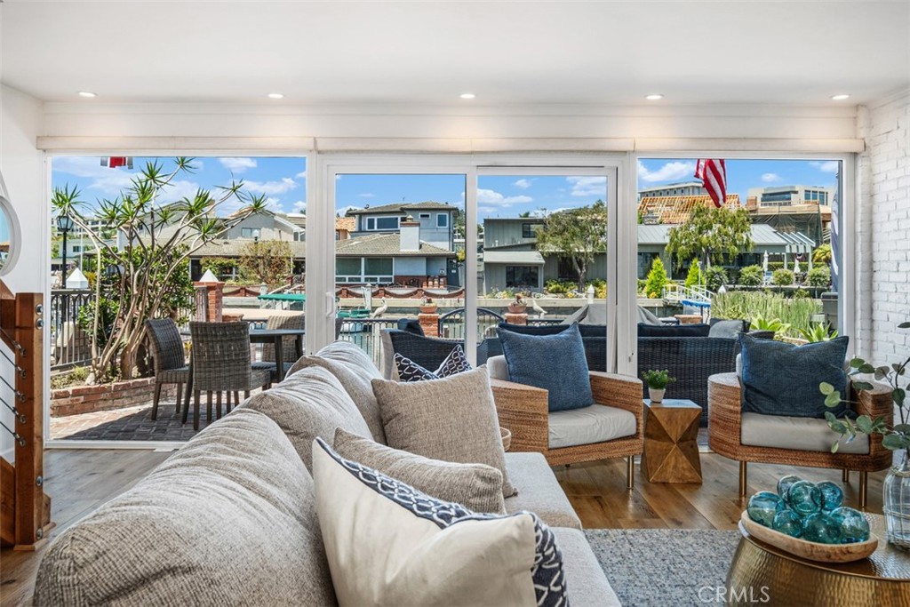 3810 Channel Place Newport Beach, CA 92663 - Photo 10 of 43 a living room with furniture a dining table and a floor to ceiling window