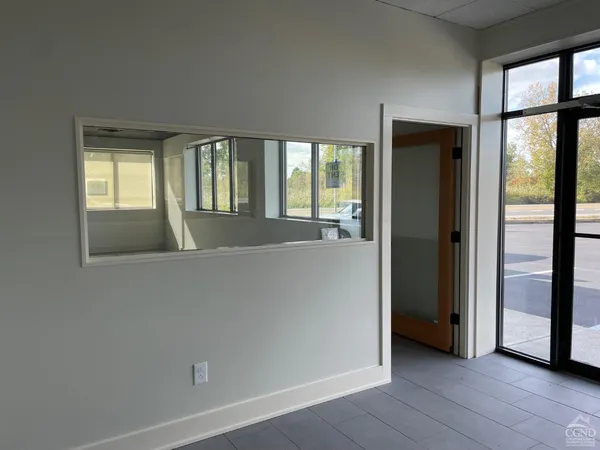 an empty room with large windows and city view