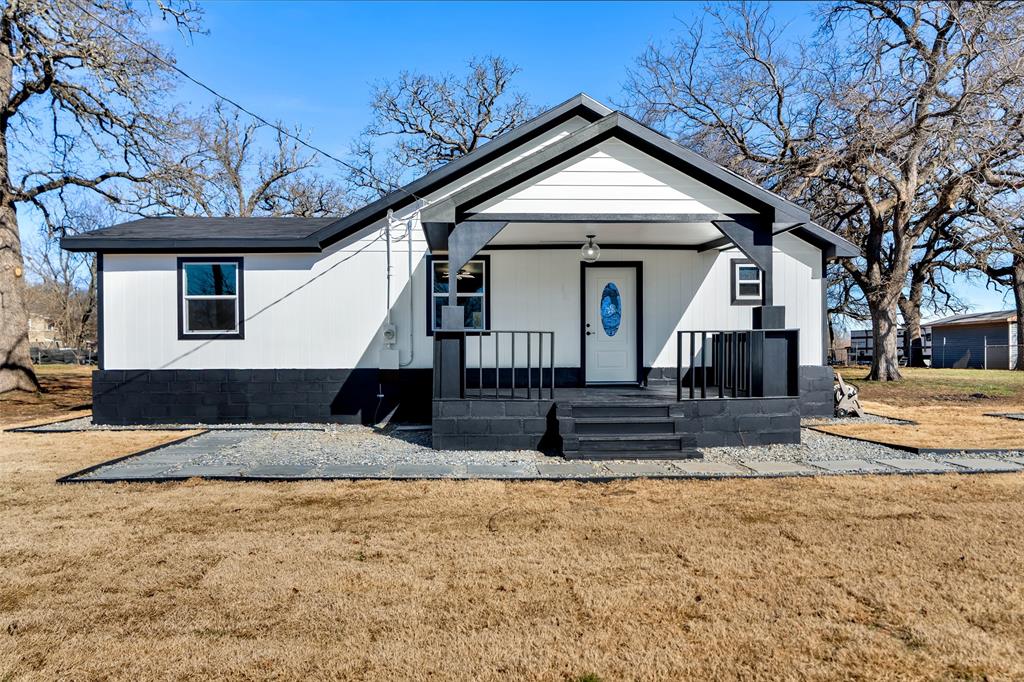 View of front of property featuring covered porch and a front lawn